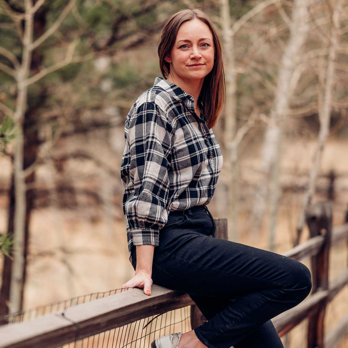 Me, Jacquelyn, sitting on the split rail fence outside my home